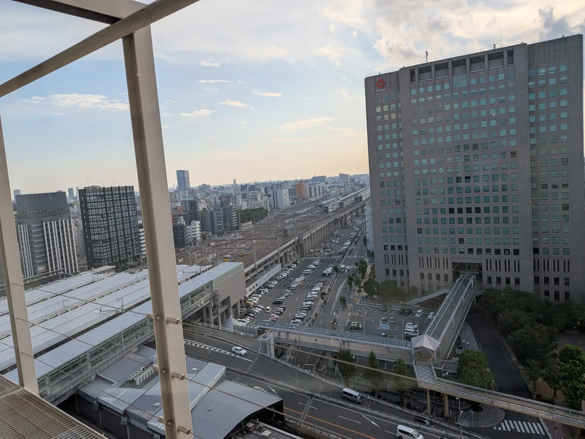 ラウンジ19階の窓から見た夕方の新大阪駅。新幹線ホームと高架、周辺のビル群が広がる