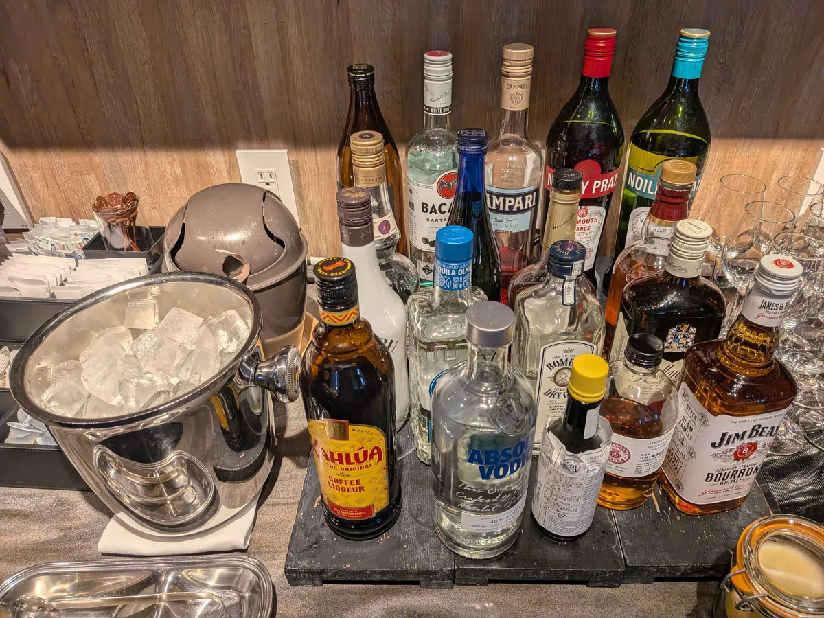 ラウンジのバーコーナー。スピリッツのボトルとアイスペールが並ぶ