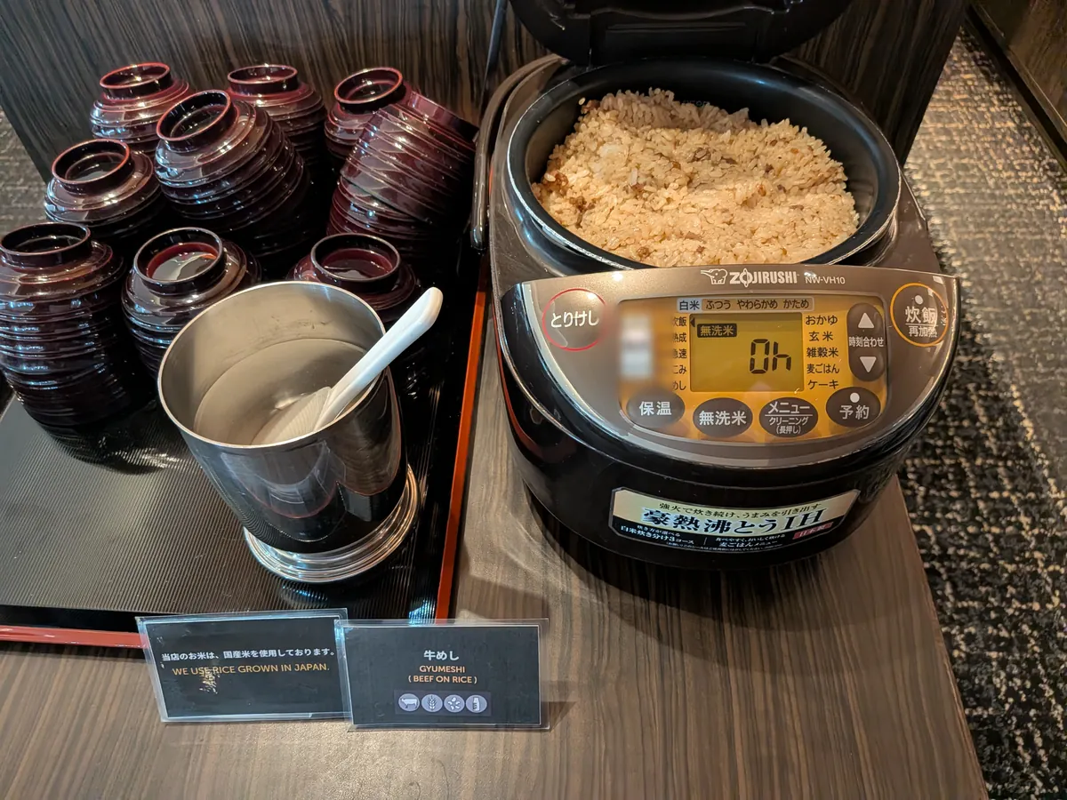 牛めしの炊飯器と塗りのお椀、出汁のポットが並ぶコーナー