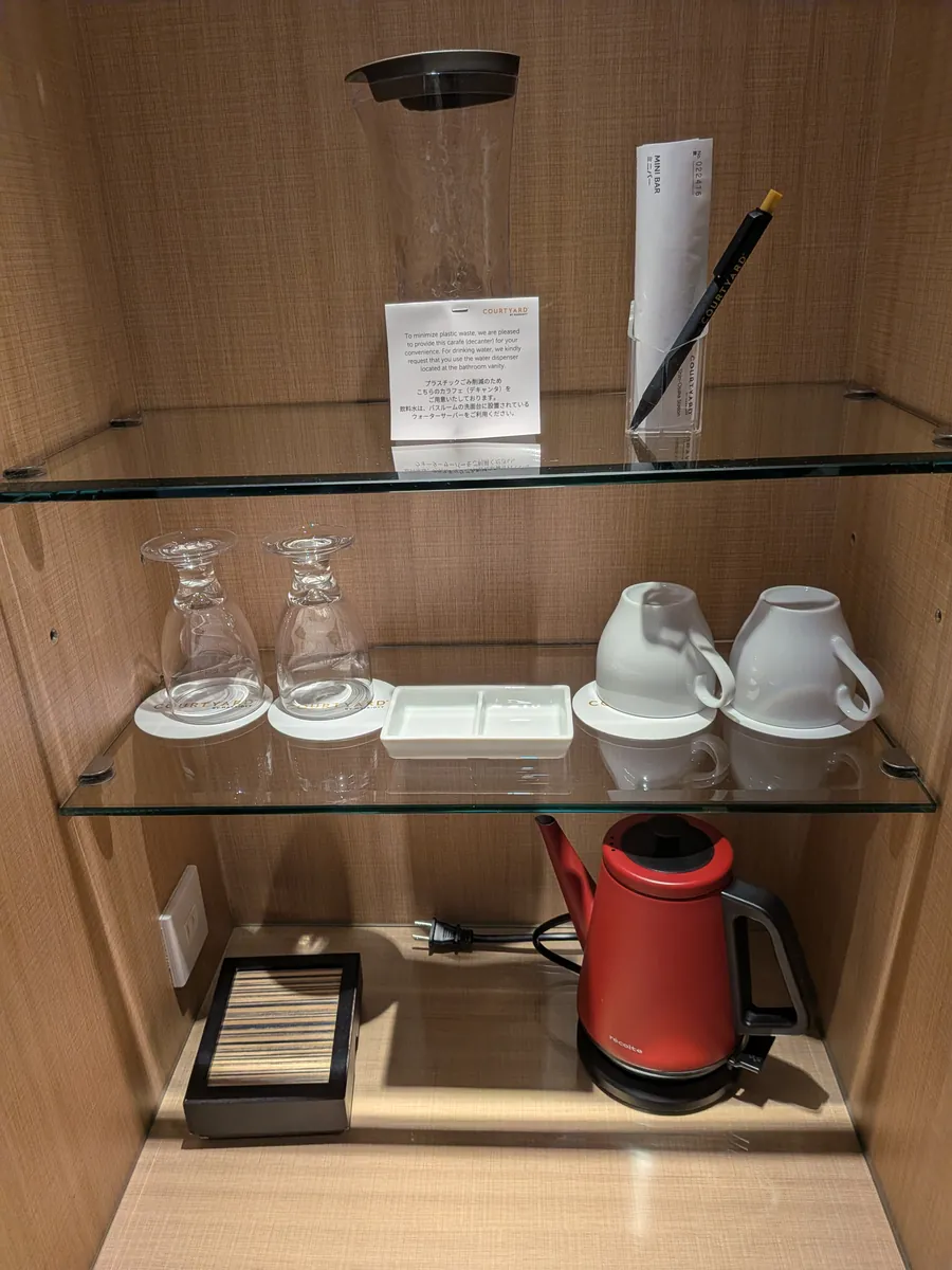 客室のグラスとカップ、赤い電気ケトルとティーバッグが並ぶコーナー