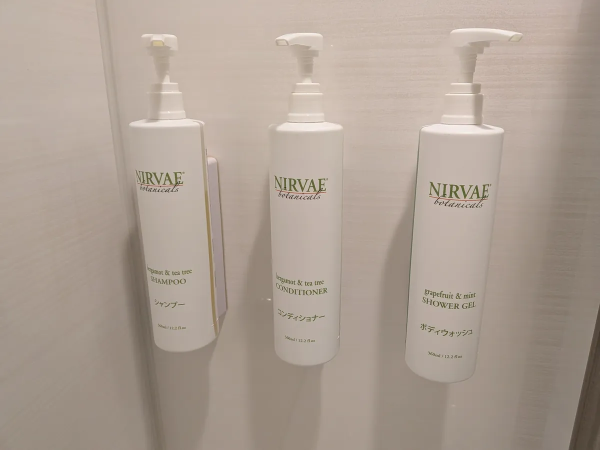 浴室の壁に設置されたNIRVAE botanicalsのシャンプー・コンディショナー・シャワージェル