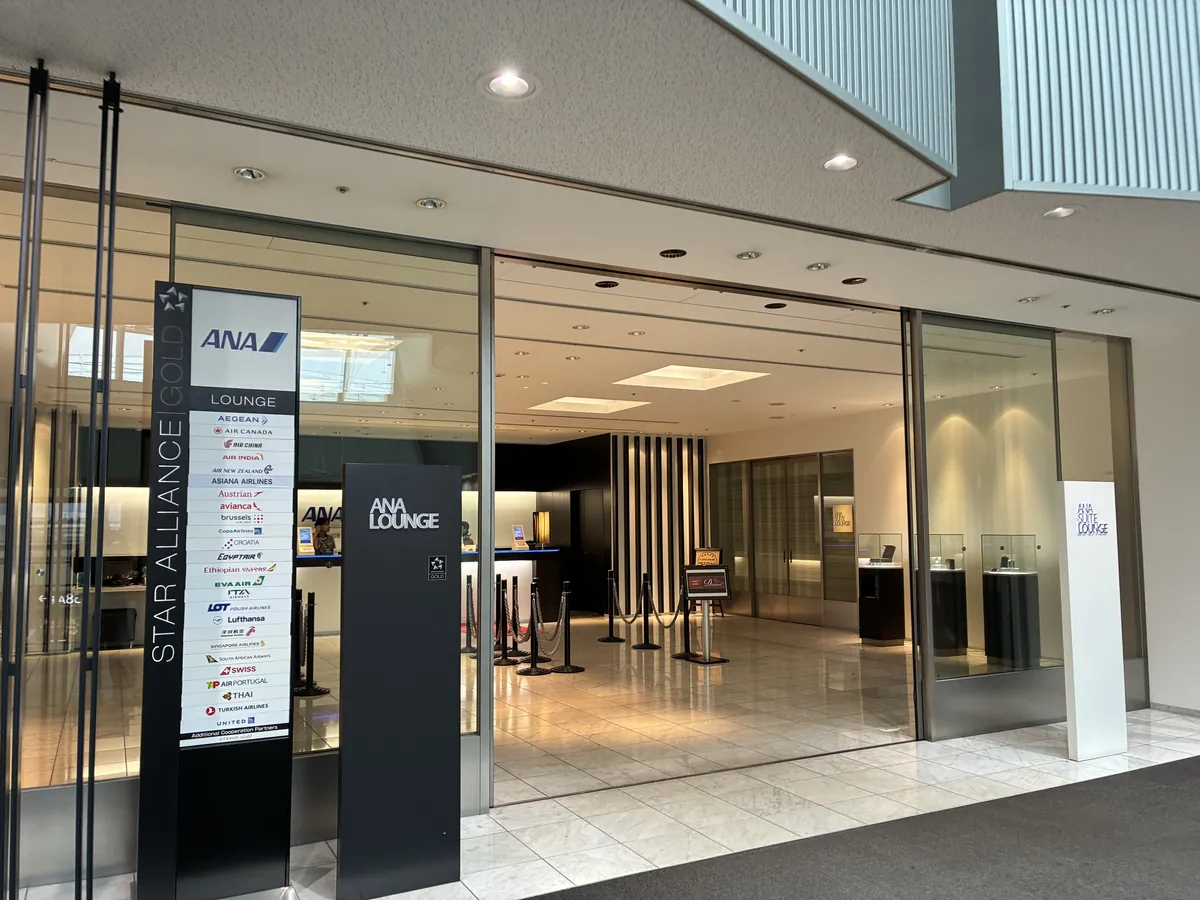 ANA LOUNGEの広々とした入口。ガラス扉の向こうに受付カウンターが見え、スターアライアンス加盟航空会社のロゴが掲示されている。