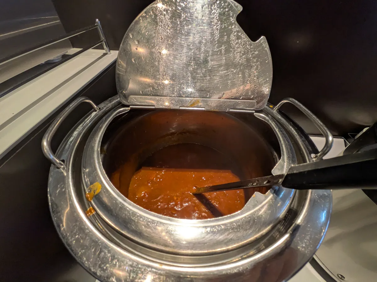 ラウンジの温かい料理コーナーに設置された、カレーがたっぷり入った保温器。