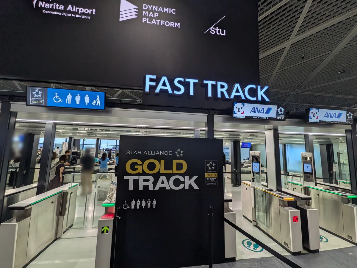 空港の優先搭乗レーン「FAST TRACK」と「GOLD TRACK」の入口。ANAのロゴが見える自動改札のようなゲートが複数並んでいる。