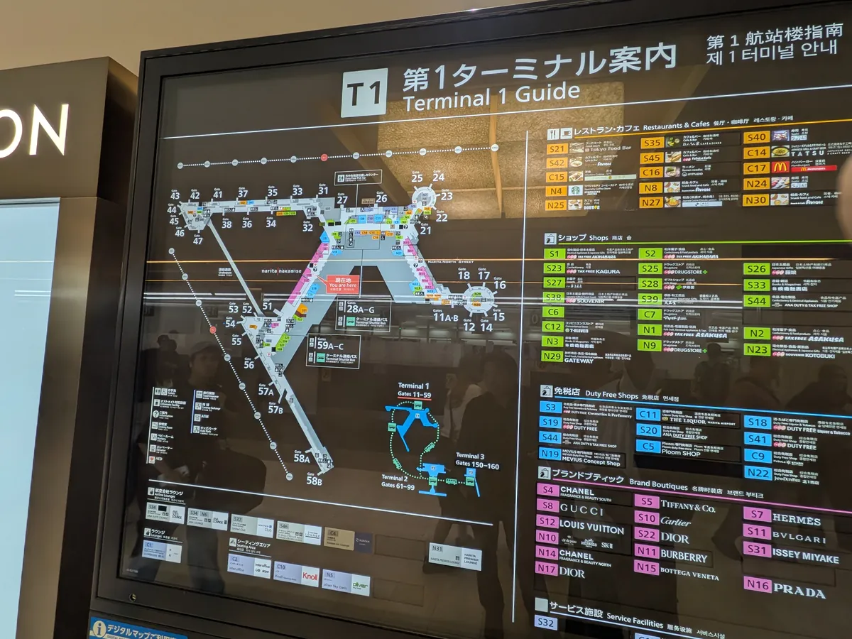 空港ターミナル内のフロアマップ。レストランやカフェ、ショップ、免税店など、施設全体の配置が詳細に示されている案内板。