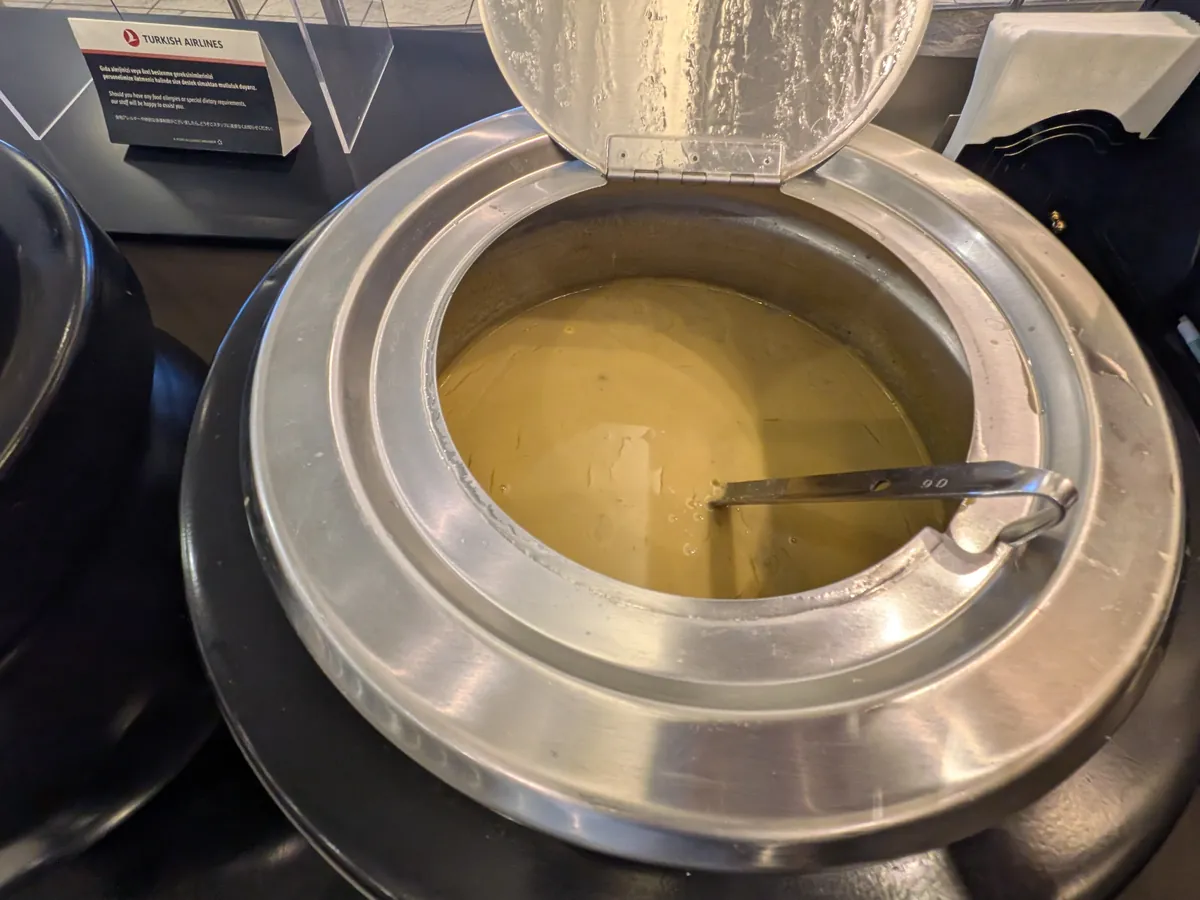 ビュッフェカウンターの温かい料理。別の種類のスープが大きな丸い保温器に入って提供されており、温かい状態を保っている。