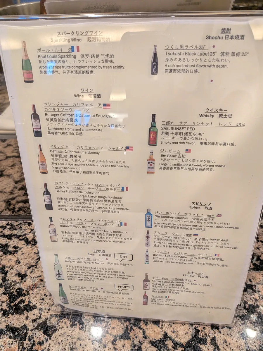 ラウンジのドリンクメニュー。スパークリングワイン、ワイン、焼酎、ウイスキーなど、様々なアルコール飲料が日本語と英語で紹介されている。