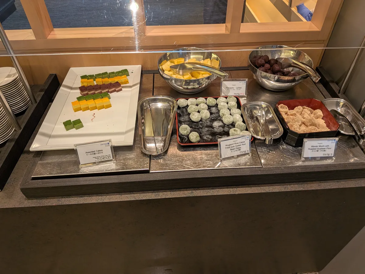 ラウンジのデザートコーナー。アソートケーキ、ミニフルーツロール、わらび餅などが並べられている。