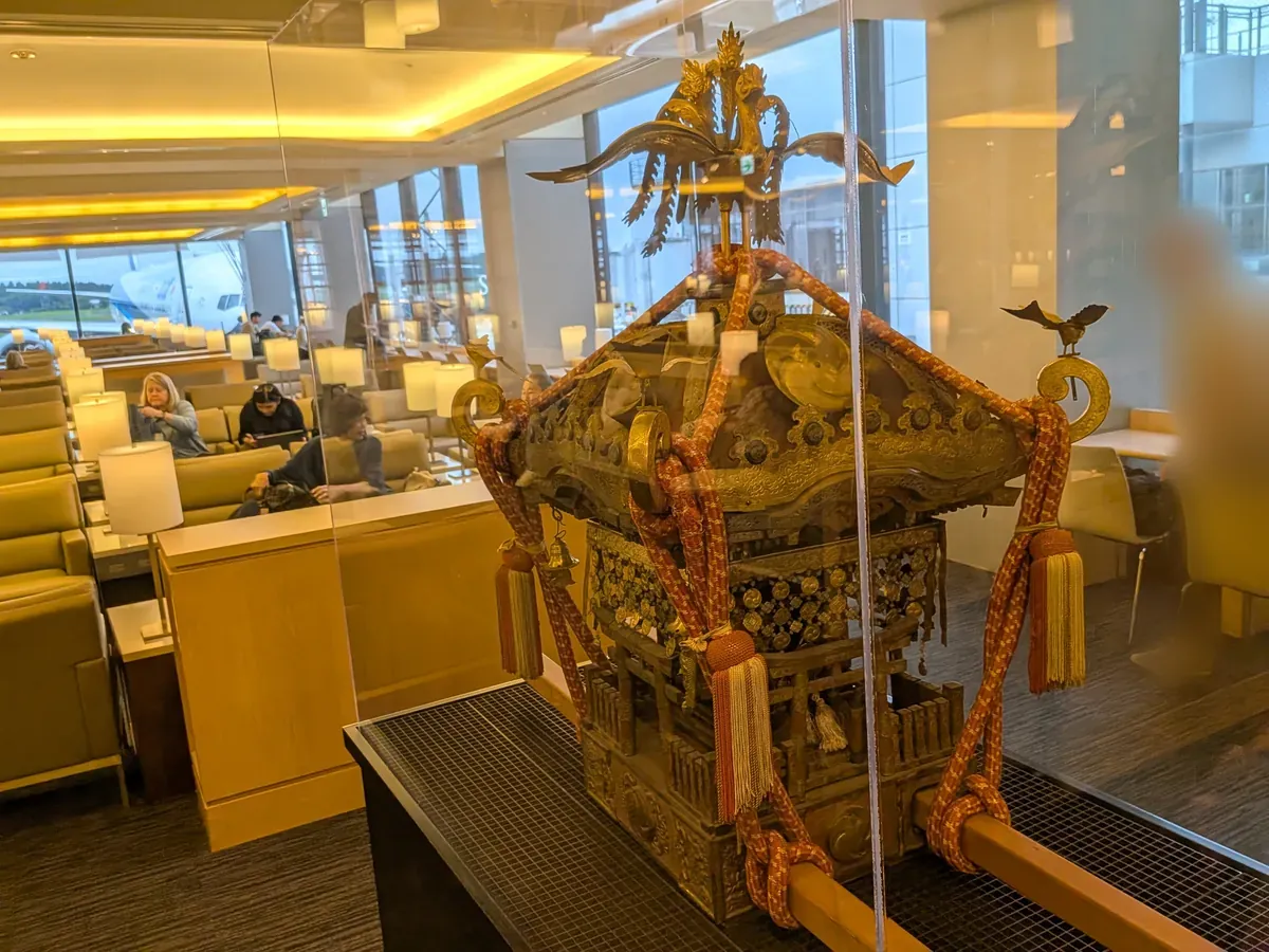 ラウンジ内に飾られた豪華な装飾の展示物。奥の窓からは駐機中の飛行機が見える。
