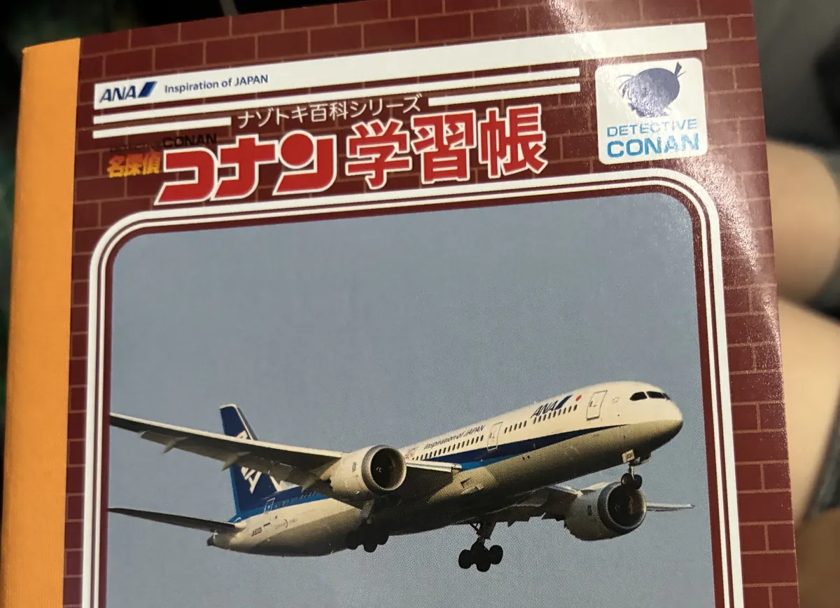 名探偵コナン学習帳の表紙。ANAの旅客機の写真と、右下に機体の型番B787-9の表記