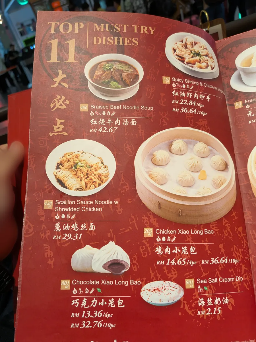 人気メニュー表「TOP 11 MUST TRY DISHES」。牛肉麺や鶏肉小籠包が価格つきで掲載