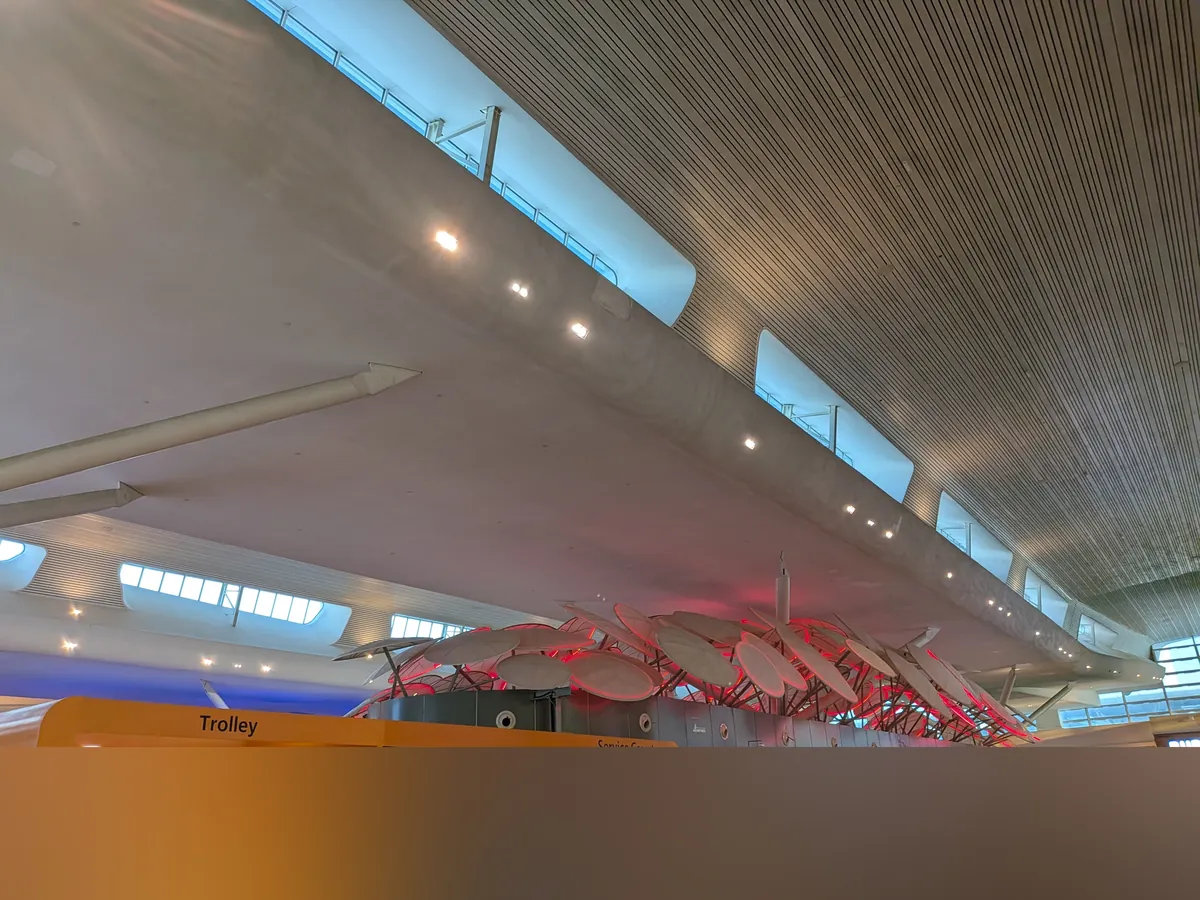 klia2のチェックインホール。曲線を描く白い天井と、赤くライトアップされた凧のオブジェ