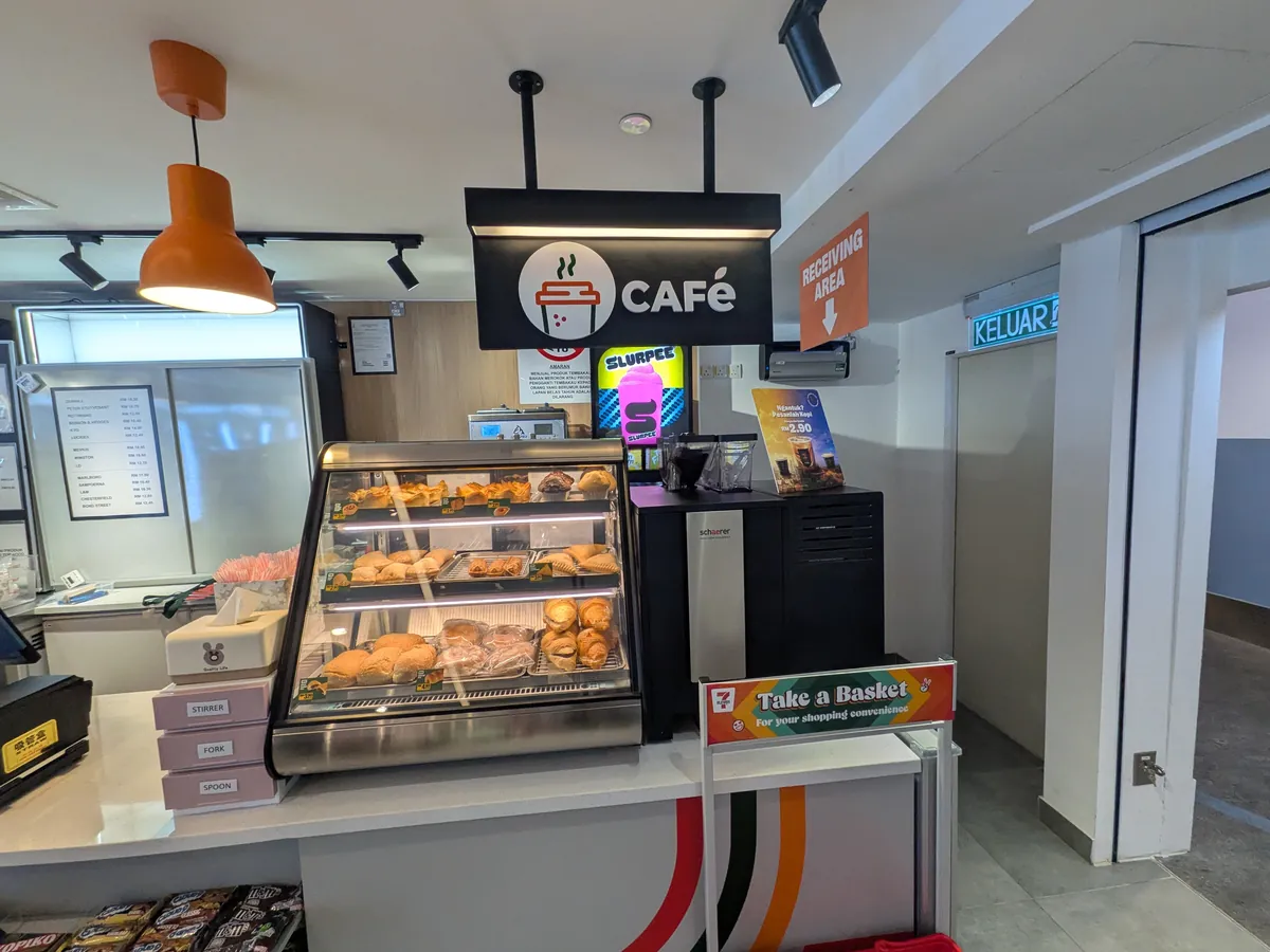 制限エリア内のコンビニのCAFéコーナー。コーヒーマシンとパンのショーケース