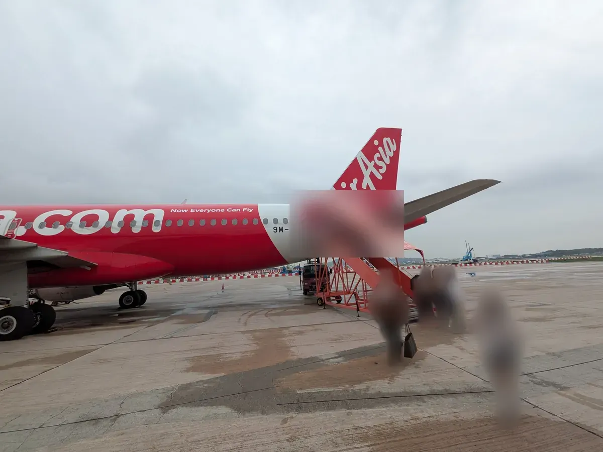 タラップから搭乗するエアアジア機。赤い機体と垂直尾翼のAirAsiaロゴ
