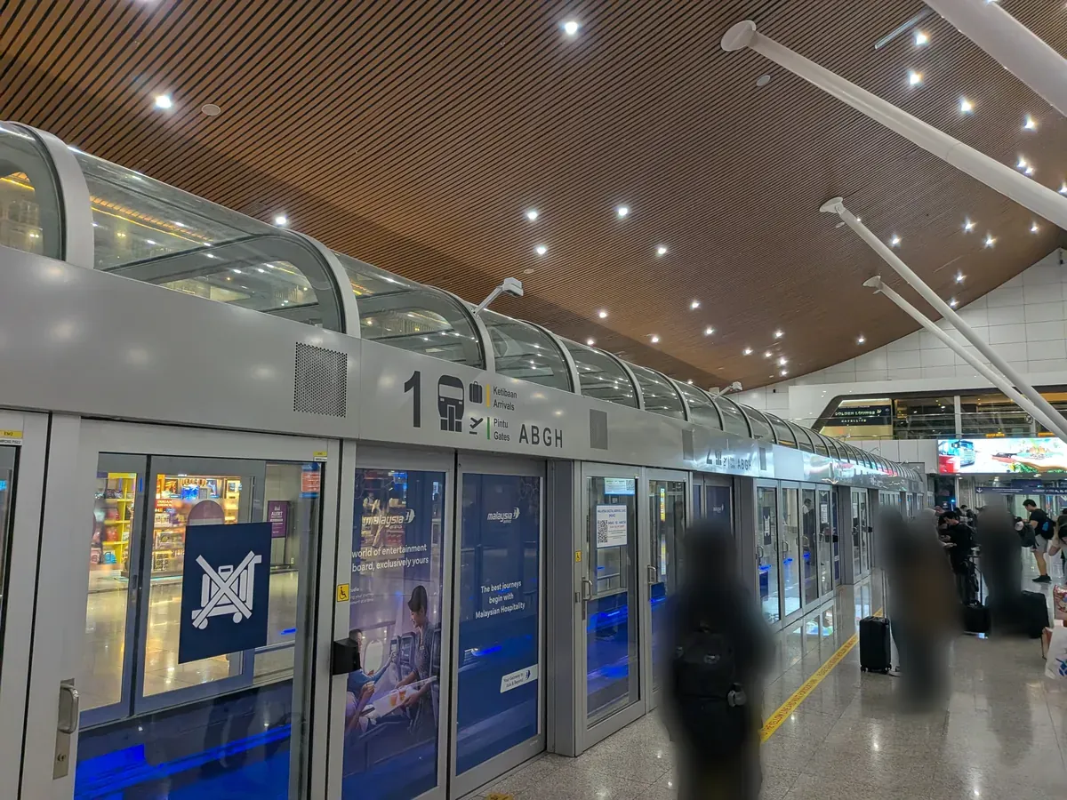 KLIA Aerotrainのホーム。ホームドアに「Ketibaan Arrivals」「Pintu Gates ABGH」の表示