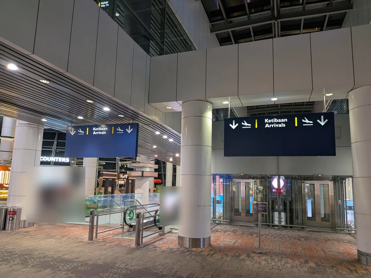 KLIA第1ターミナルの「Ketibaan / Arrivals」到着案内サインと到着ロビーの入口