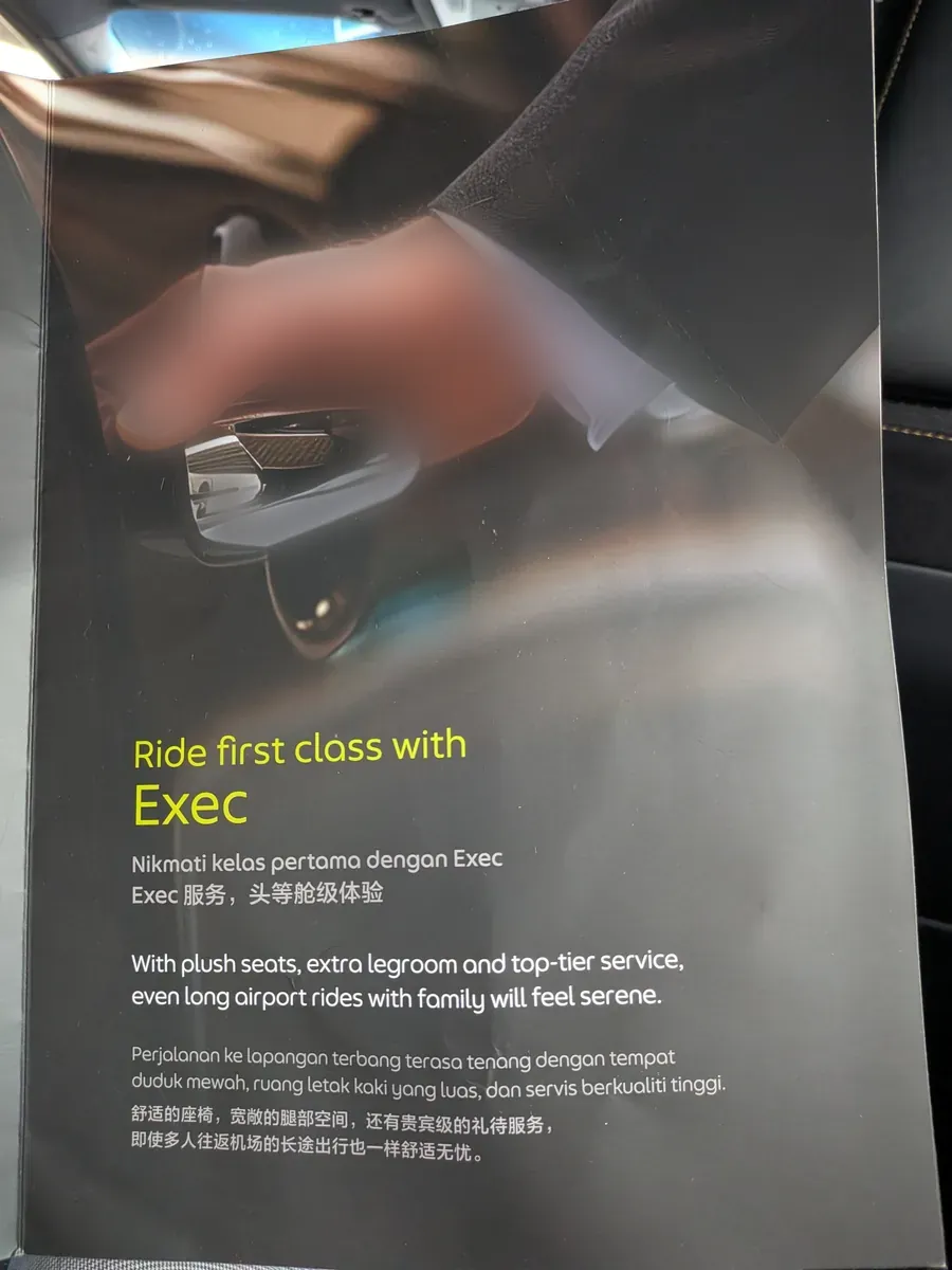 Grab Execの案内カード。「Ride first class with Exec」の見出しと、ゆったりした座席と広い足元スペースを説明する多言語のテキスト