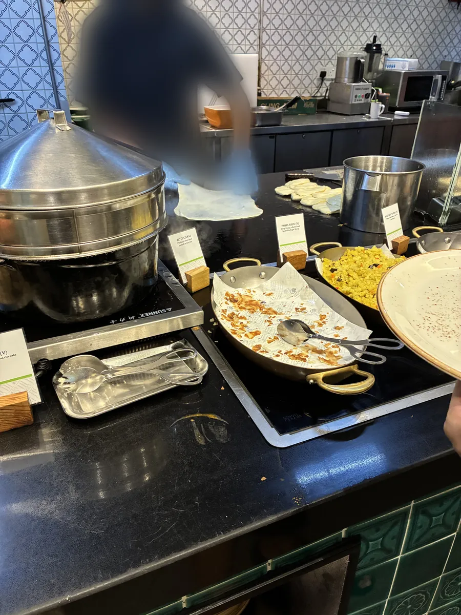 シェフが鉄板でナンを焼いているところ