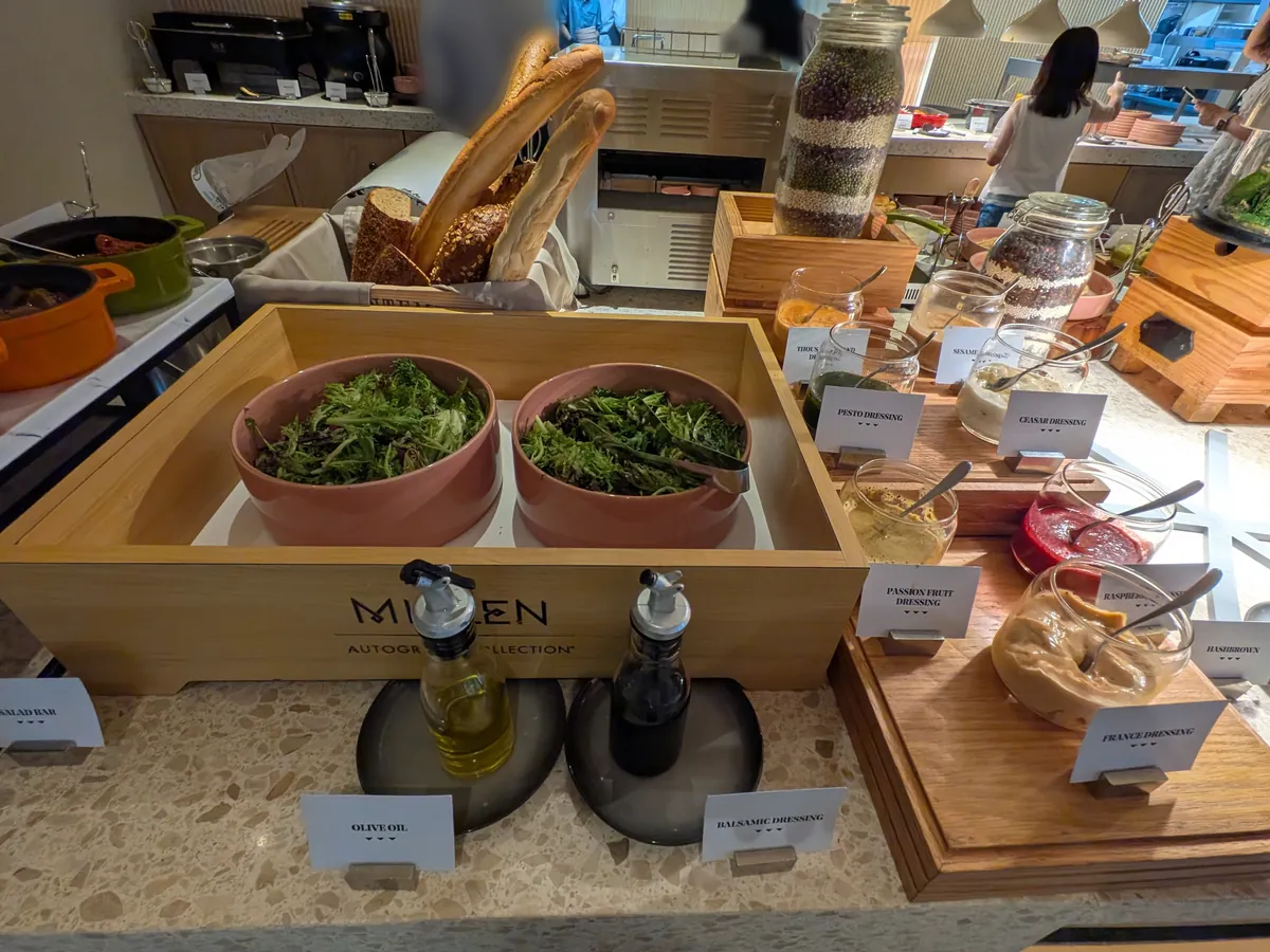 サラダのコーナー。生野菜の入った器とTHE MILLENのオイル・ビネガーのボトル