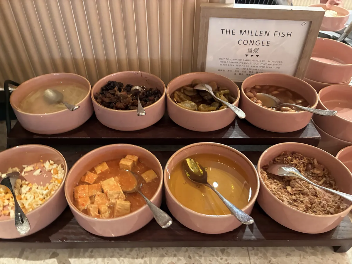 お粥のコーナー。THE MILLEN FISH CONGEEの札と、薬味を入れた陶器の器がずらりと並ぶ