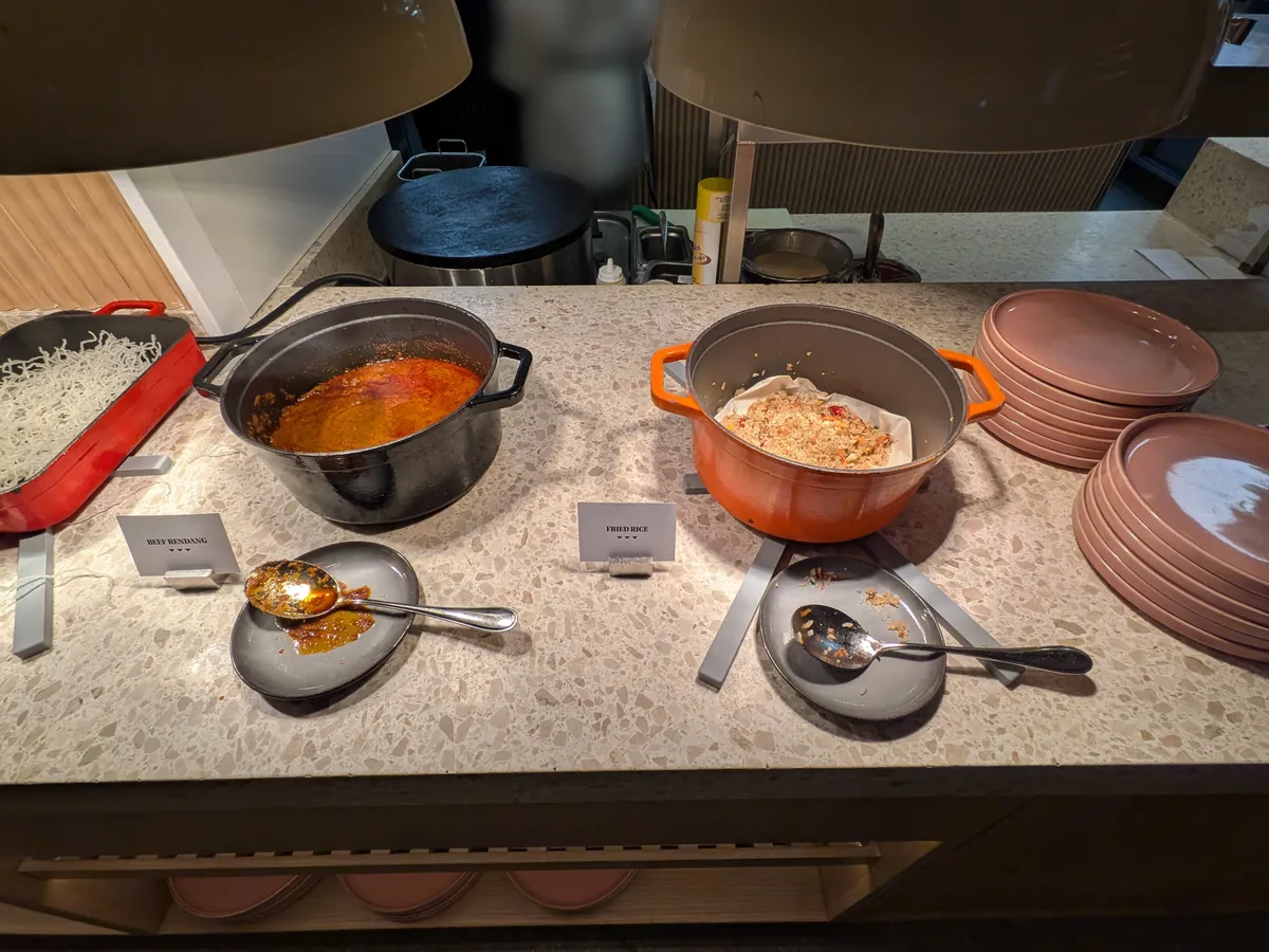 オレンジ色の鋳物鍋に入った煮込み料理と取り分け皿