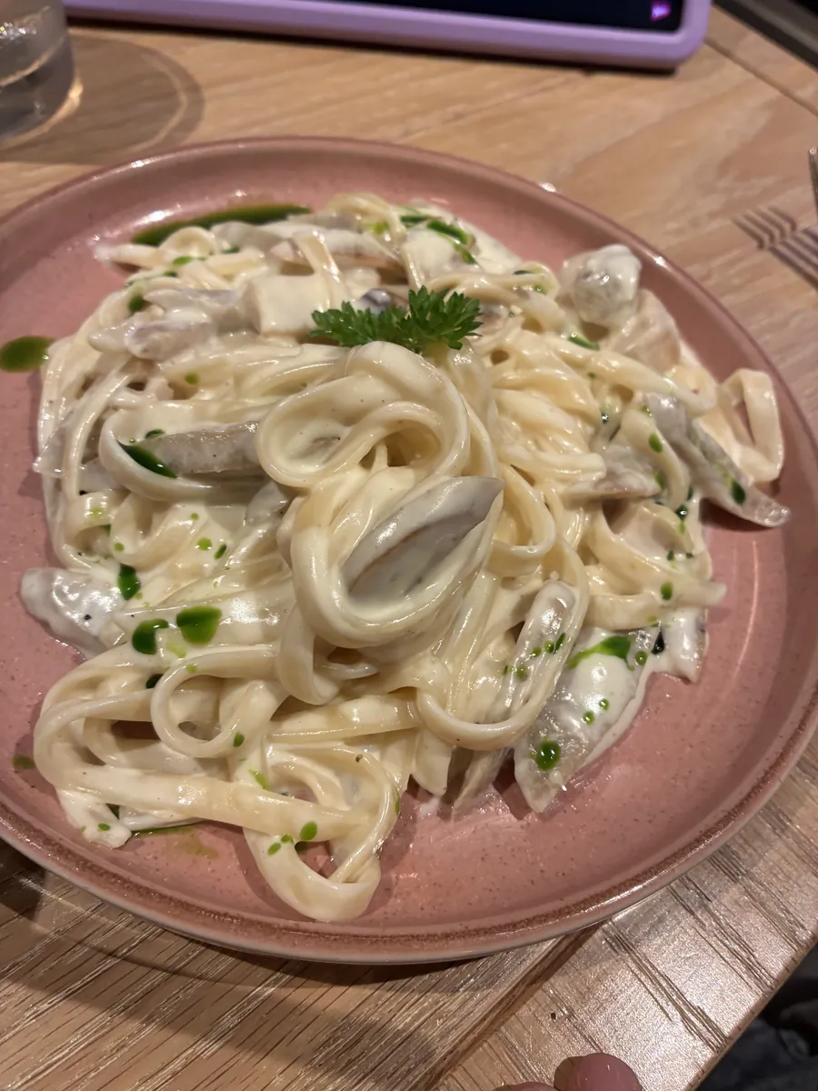 クリームソースのパスタ。きのことハーブがのっている