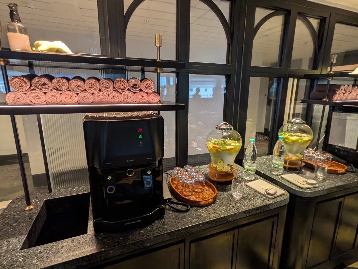 ジム入口のコーヒーマシンとインフューズドウォーター、タオル