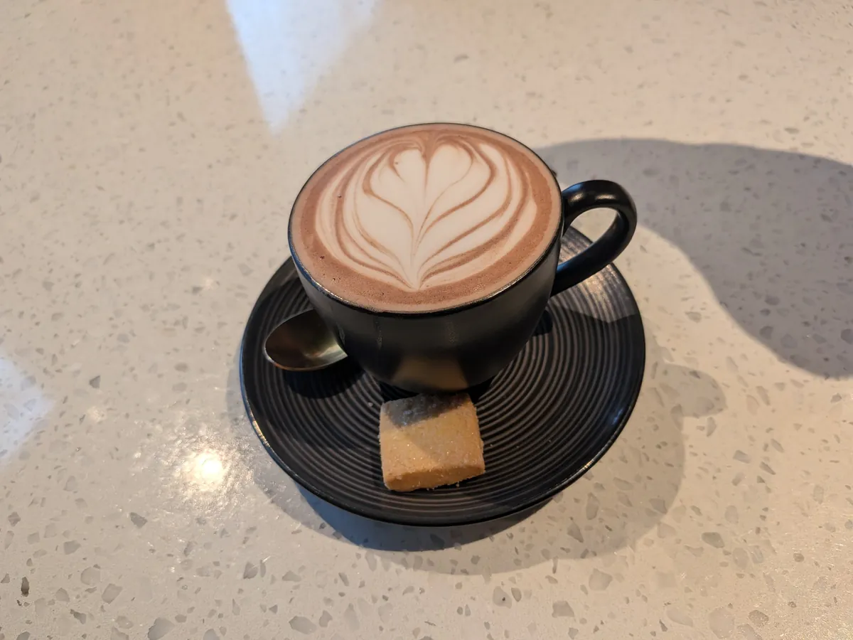 2杯目のカプチーノ。ソーサーの上に小さな焼き菓子が添えられている
