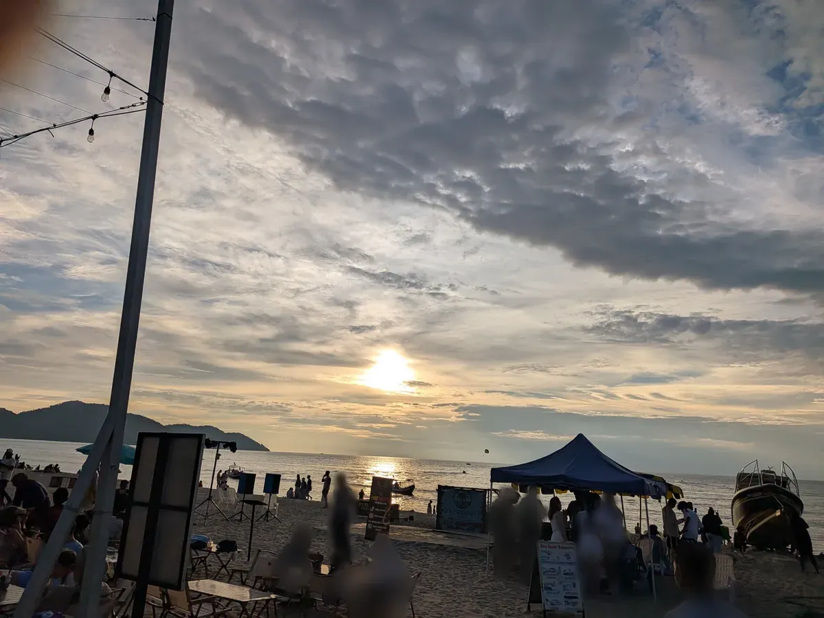 夕方の砂浜。店の設営が始まりテントとガーランドが張られている