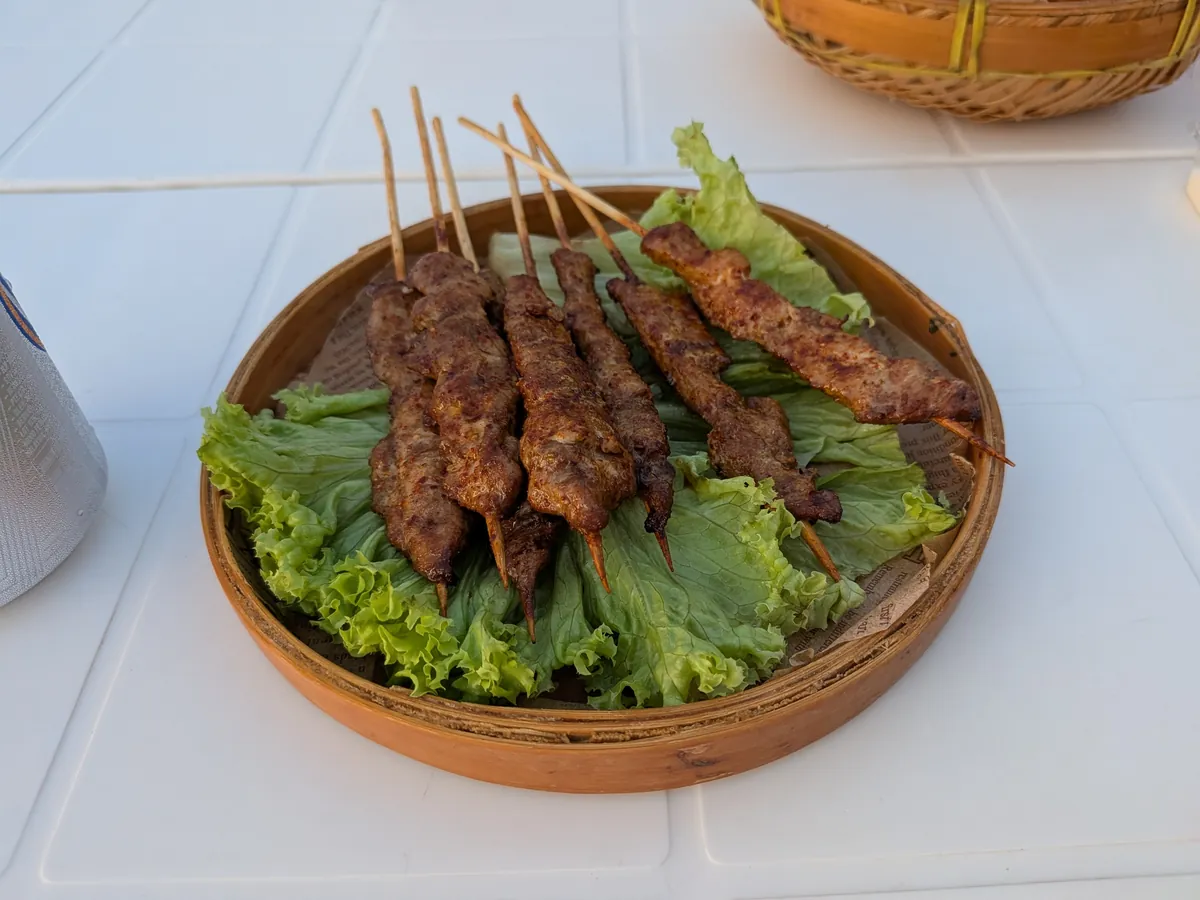 籐の籠に盛られたサテ（串焼き）