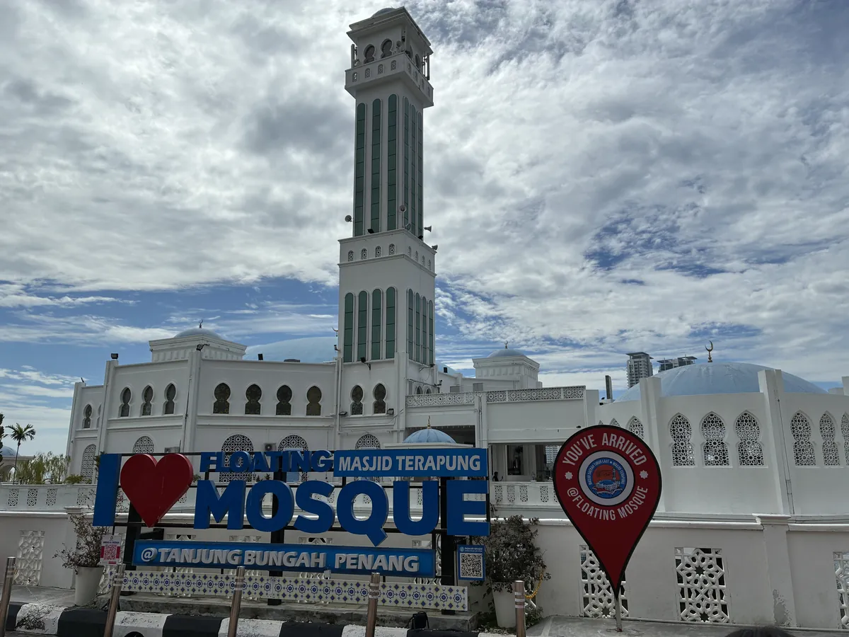 水上モスクの入口にあるI♥MOSQUEの看板とミナレット