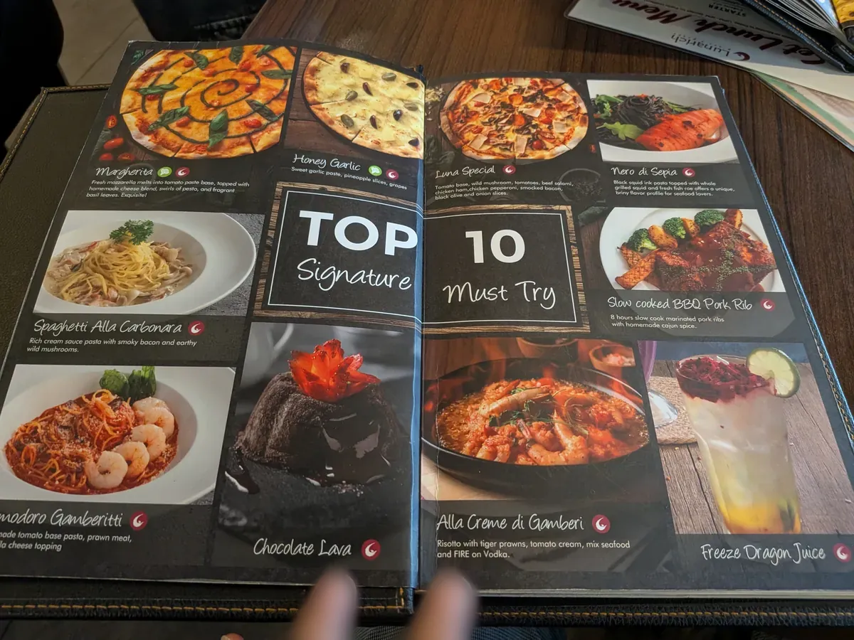 メニューの見開き『TOP 10 Signature Must Try』。マルゲリータ、イカスミのネロ・ディ・セピア、カルボナーラ、BBQポークリブ、チョコラバなどが写真付きで並ぶ