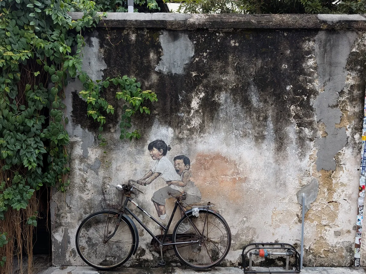 ペナンで最も有名な壁画Kids on Bicycle。古びた壁に描かれた姉弟と、壁に据え付けられた本物の自転車