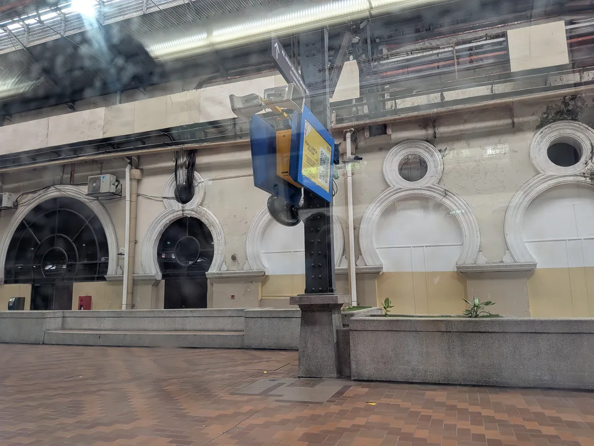 車窓から見た旧クアラルンプール駅のホーム。白い円窓とアーチが並ぶムーア様式の駅舎