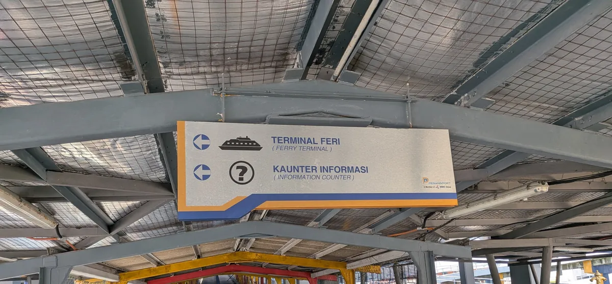 TERMINAL FERI(フェリーターミナル)とKAUNTER INFORMASI(案内所)の方向を示す吊り看板
