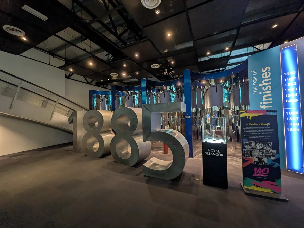 創業年を示す巨大な「1885」のオブジェと、仕上げ技法を並べた the hall of finishes の回廊