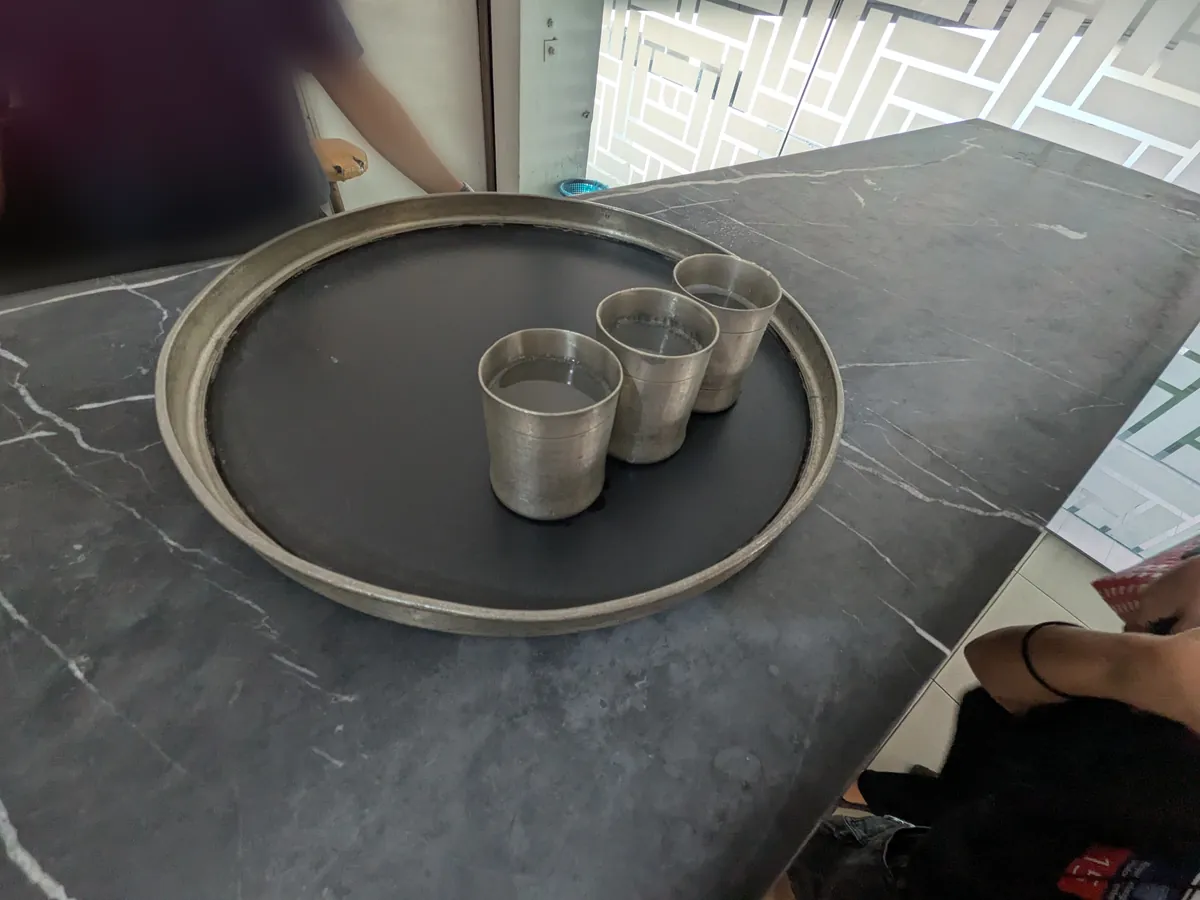 ピューター製のカップで提供される冷たいドリンクのサービス。トレイに3杯