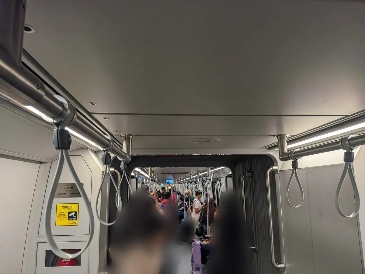 清潔で明るいLRTクラナジャヤ線の車内。吊り革が並ぶ