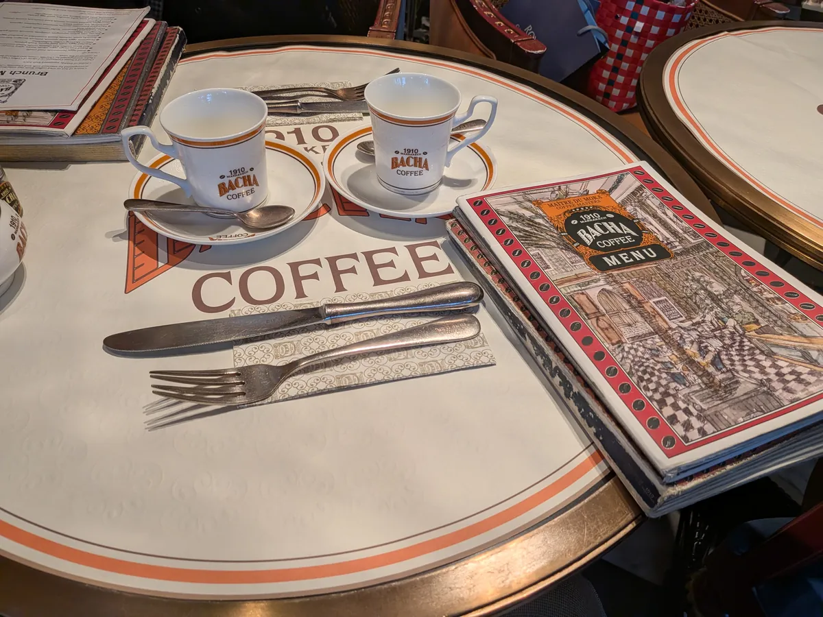 バチャコーヒーの卓上。白地にオレンジのラインが入ったカップとメニューブック