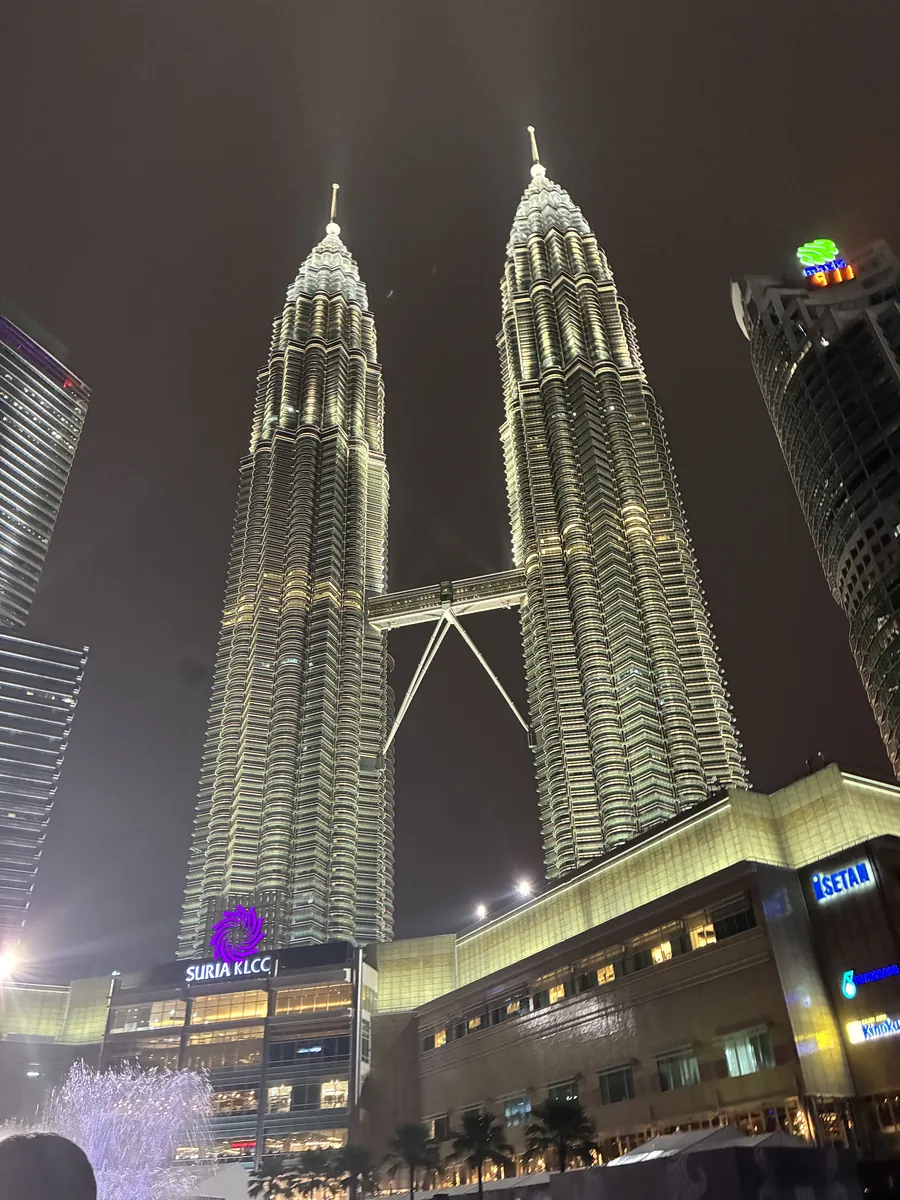 夜のペトロナス・ツインタワー全景とその足元に広がるスリアKLCC
