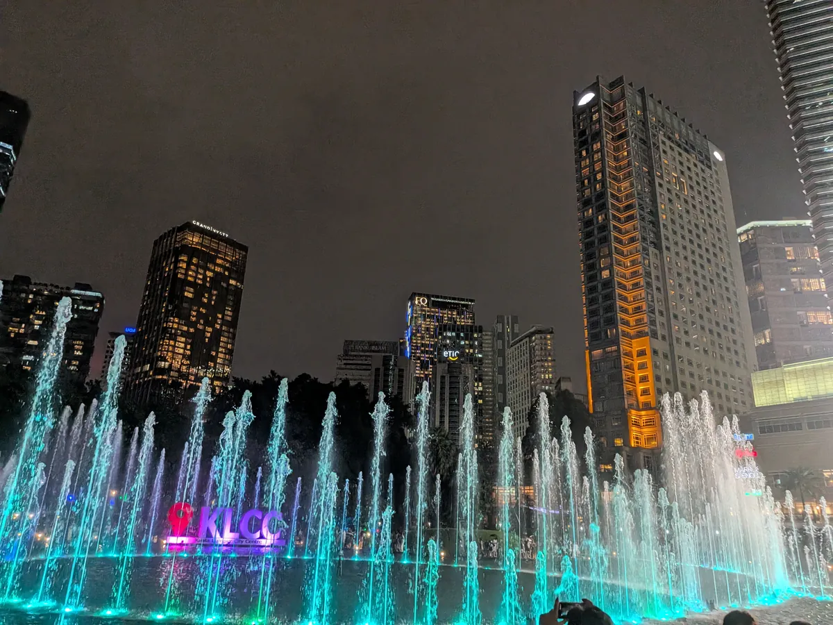 噴水が上がるKLCC公園の湖と、水中に浮かぶKLCCの文字