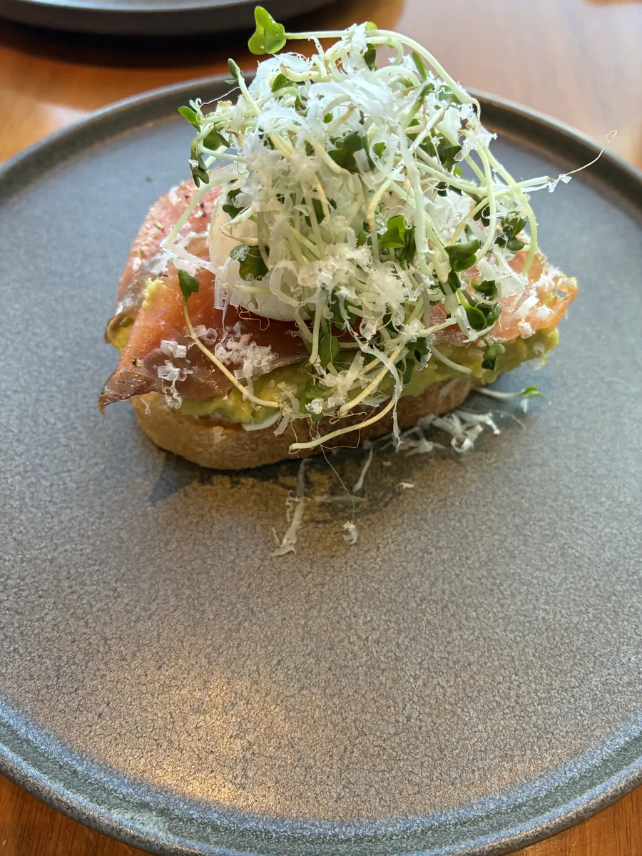 Daily Specialのアボカドトースト。スモークサーモンとポーチドエッグにマイクログリーンとチーズ