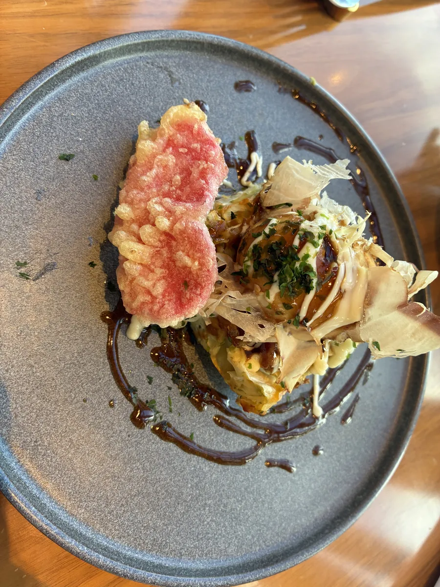 シグネチャーのお好み焼きベネディクト。紅ショウガ天と鰹節が添えられている