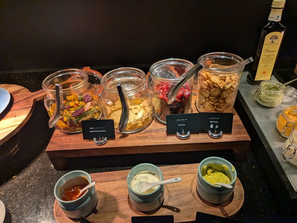 ピクルスの瓶とナッツが並ぶカクテルタイムのつまみコーナー