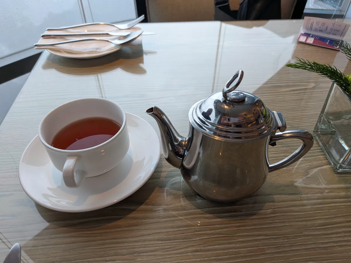 銀のポットで提供される紅茶とカップ