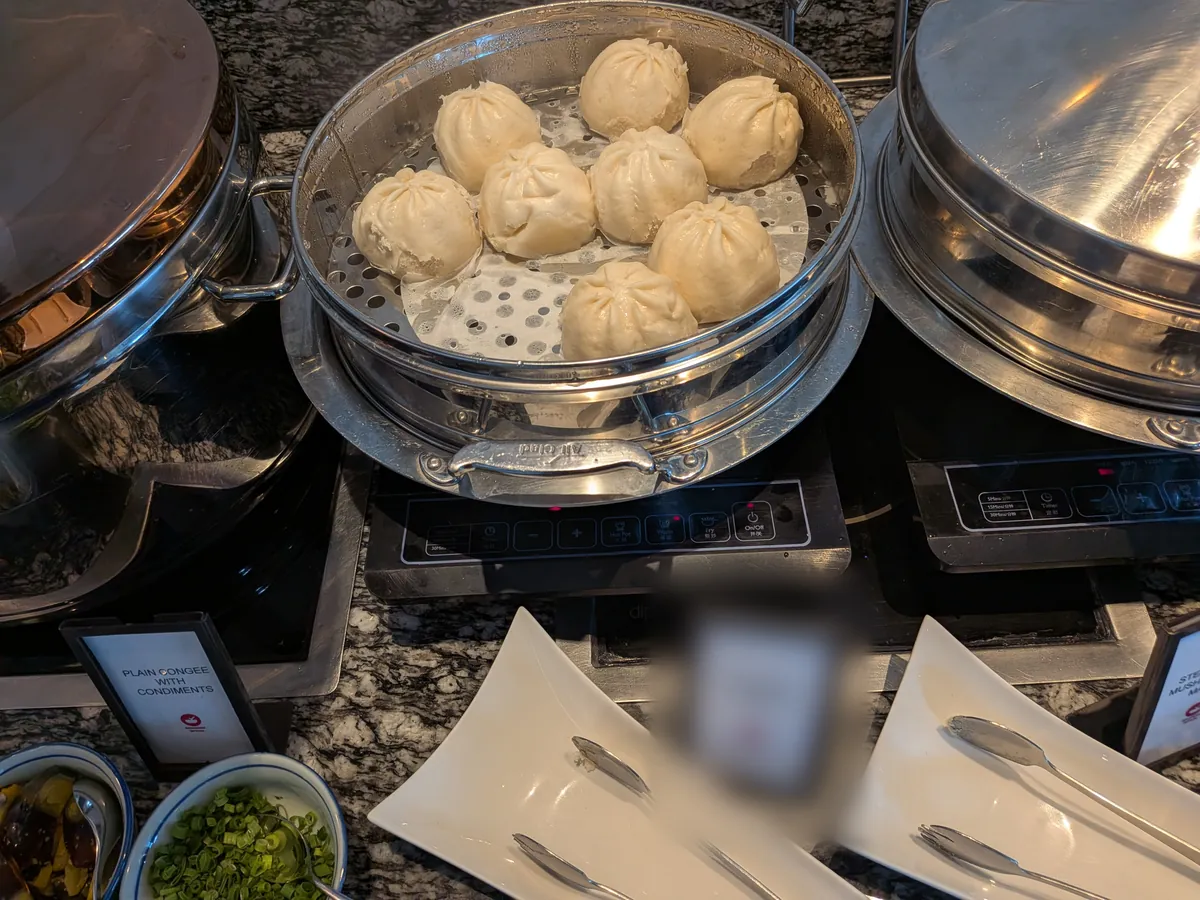 蒸籠に入った肉まんと、PLAIN CONGEE WITH CONDIMENTSと書かれたお粥コーナーの札