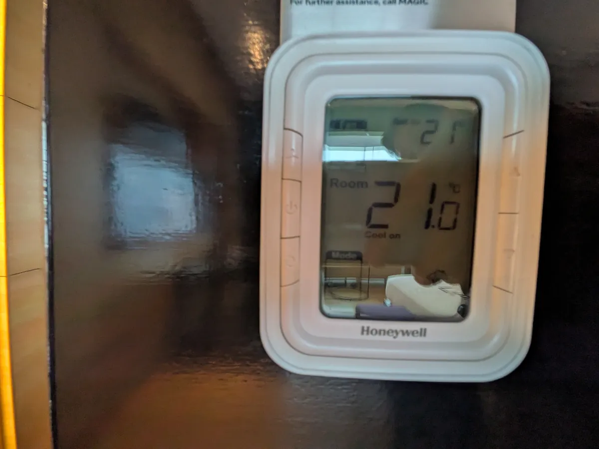 壁付けのサーモスタット。室温21.0度に設定されている