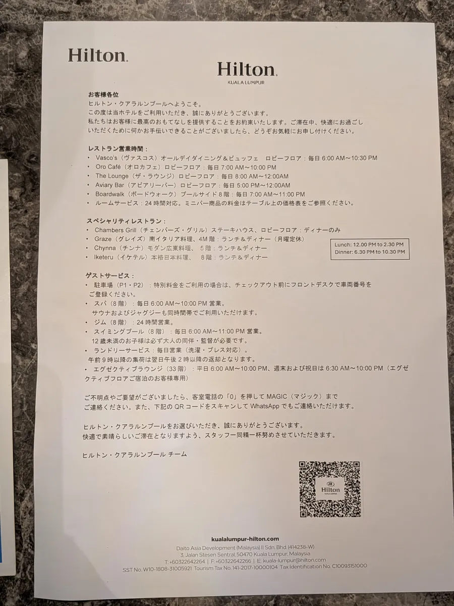 日本語で書かれたヒルトン・クアラルンプールの館内案内。レストラン営業時間やプール・ジム・ラウンジの利用時間が一覧になっている