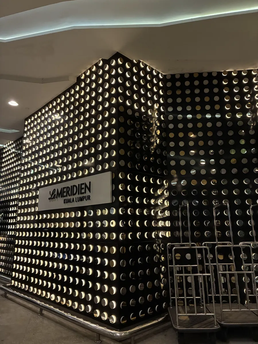 金色の丸い突起を並べた壁にLE MERIDIEN KUALA LUMPURの文字が浮かぶ