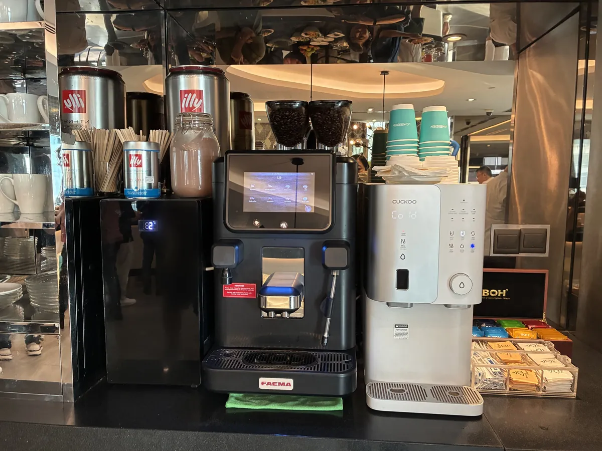 illyのコーヒーマシンとカップ、紅茶のティーバッグが並ぶドリンクコーナー